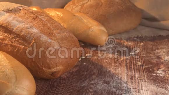 把小麦放在一张有新鲜面包的乡村老桌上视频的预览图