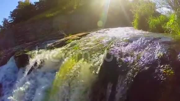 鸟瞰绿色湍流瀑布阳光慢镜头视频的预览图