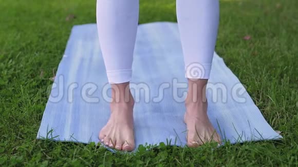 蓝色瑜伽垫做瑜伽特写的女人视频的预览图