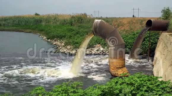 生锈的大管道产生的废水流入河流视频的预览图