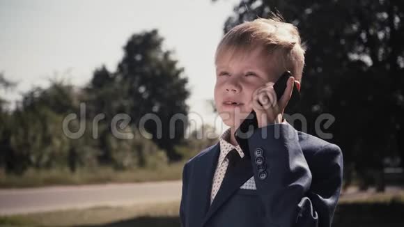 穿着西装打领带的小男孩打电话视频的预览图
