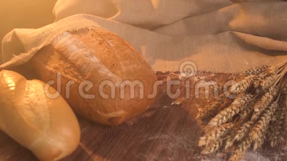 把新鲜的面包放在一张带小麦的乡村老桌上视频的预览图