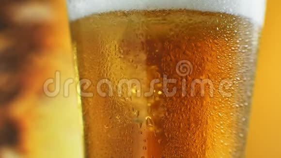 啤酒正倒入角玻璃中IPA启动了在装有水滴的杯子里喝冷光啤酒啤酒制造波浪视频的预览图
