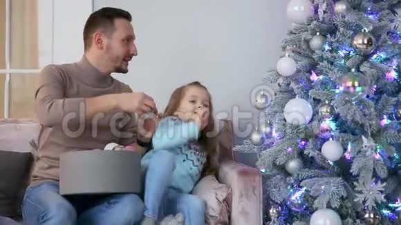 爸爸和女儿装饰圣诞树视频的预览图