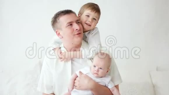 父亲和两个儿子坐在家里视频的预览图