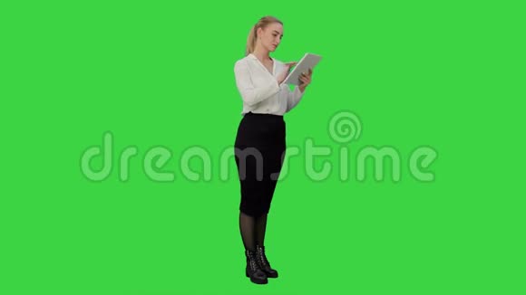 女商人站在数字平板电脑和工作的绿色屏幕铬键视频的预览图