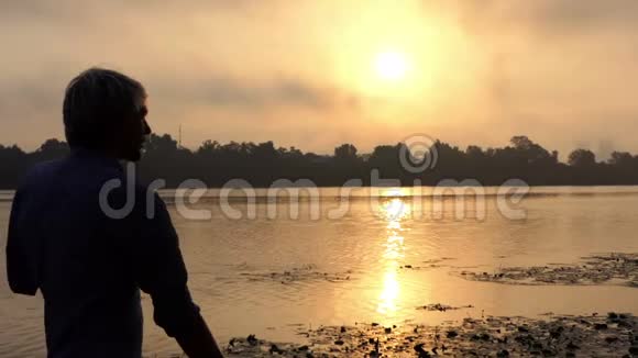 在斯隆莫的夕阳下欢乐的男人在美丽的河岸上跳舞视频的预览图