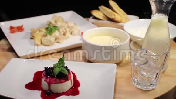 在一家餐馆里一道主菜一片沙漠和一个饮料建议的镜头在一张木桌上旋转视频的预览图