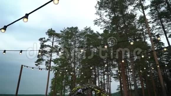 结婚结婚典礼拱门装饰着紫罗兰和黄色的矗立在树林里在婚礼上视频的预览图