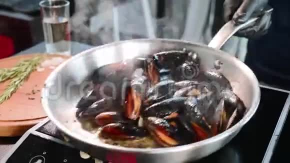 把贻贝放进煎锅里厨师将海鲜与油和调料混合视频的预览图