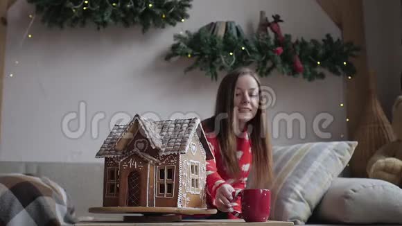 圣诞快乐假日快乐年轻女子喝着温茶和圣诞饼干视频的预览图