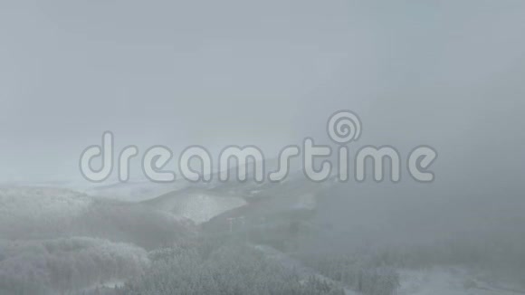 飞上白雪皑皑的冬雾蒙蒙的山林白雪覆盖视频的预览图