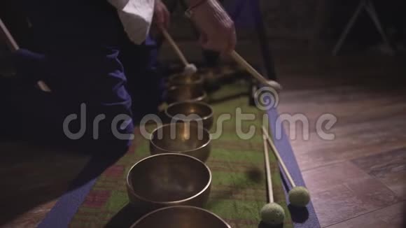 专业男青铜藏唱碗演奏者令人难以置信的声音音乐坐在地板上瑜伽冥想视频的预览图