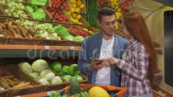 情侣们在超市讨论智能手机上的购物清单视频的预览图