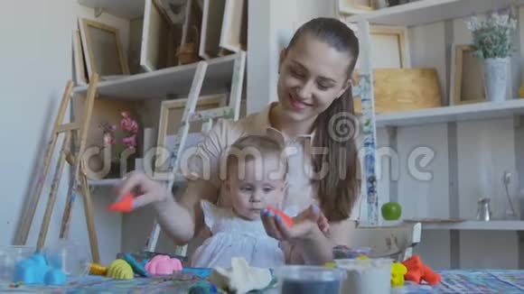 一位年轻迷人的母亲和她的孩子混合了不同颜色的塑料学前教育发展视频的预览图