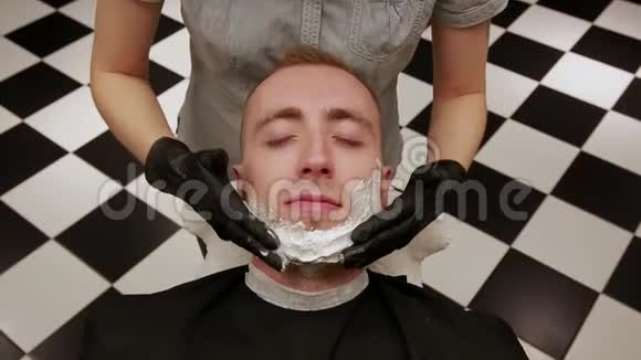 一个男人的特写脸铺着剃须泡沫理发店理发店视频的预览图