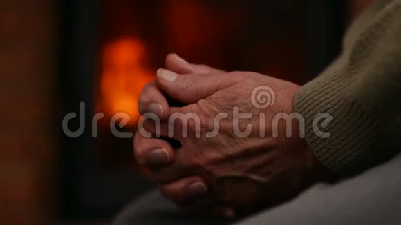 壁炉前男人和女人的双手在年老时互相安慰视频的预览图