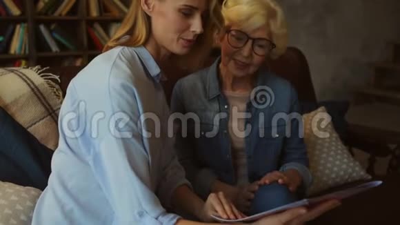 漂亮的女人和她妈妈一起读时尚杂志视频的预览图