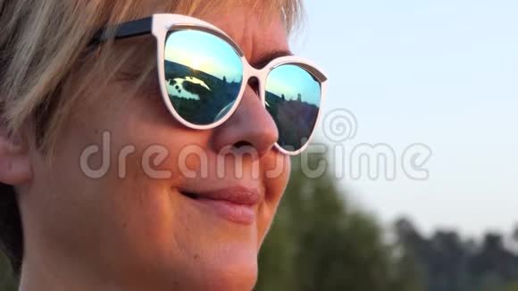美丽的中年妇女慢镜头地戴着太阳镜微笑视频的预览图
