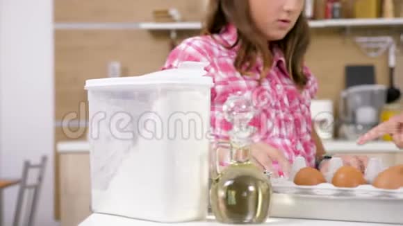关闭4K镜头的母亲和小女儿一起在厨房烘焙和烹饪视频的预览图