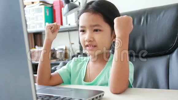 近距离拍摄亚洲小女孩使用笔记本电脑与喜悦和愉快的感觉视频的预览图