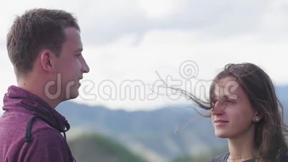 两个人在山的背景下散步蜜月亲吻山脉的背景风的发展视频的预览图