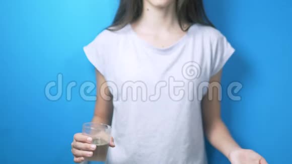 保健概念特写镜头女孩拿着一杯水和药丸视频的预览图
