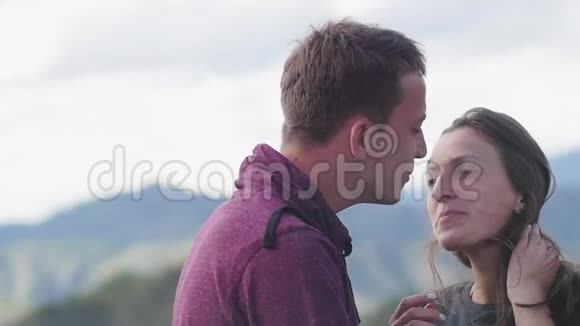 两个人在山的背景下散步蜜月亲吻山脉的背景风的发展视频的预览图