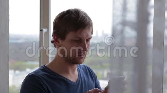 技术生活方式男人拨打电话号码在家打智能手机视频的预览图