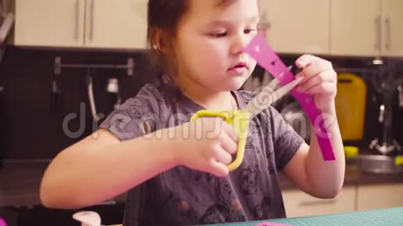小女孩用剪刀剪彩纸视频的预览图