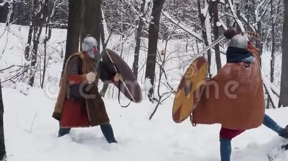 中世纪的爱尔兰和率直的勇士在冬天的森林里用剑和盾牌战斗视频的预览图
