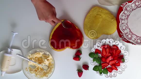 一个女人正在饼干上撒果酱茶托旁边是一个草莓有一个奶油视频的预览图