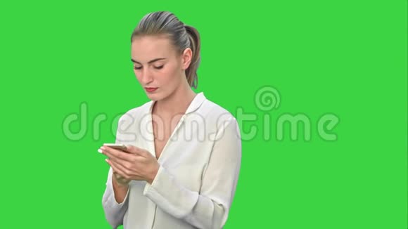 贵商女性使用手机阅读信息穿白色西装在绿色屏幕上Chroma键视频的预览图