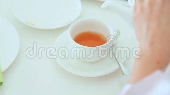 女人把茶倒进杯子里视频的预览图