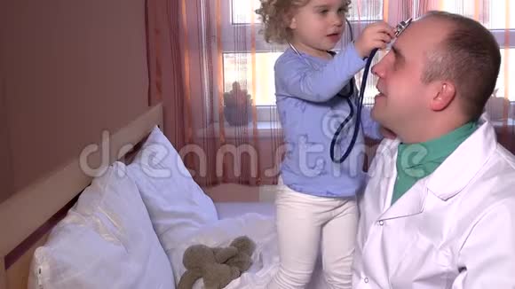 可爱的小病人在医院病床上玩他的医生听诊器视频的预览图