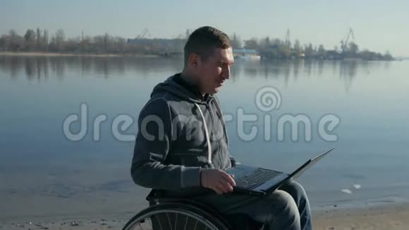 带手提电脑的残疾人在轮椅上独自引导视频聊天视频的预览图