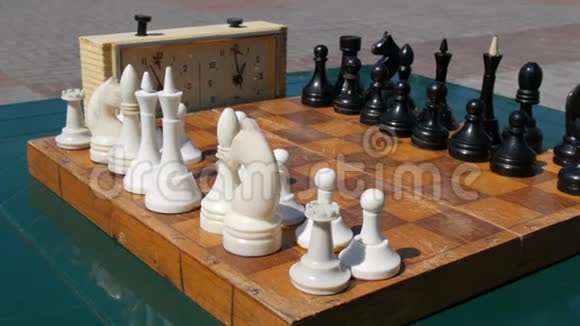 黑白棋架在棋盘上旁边是街上一个老式的象棋钟视频的预览图