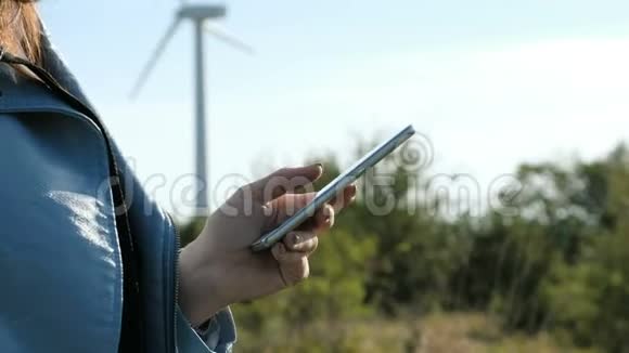 在风车农场的特写镜头里女孩用手机视频的预览图