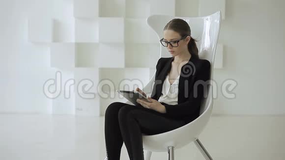 白人女性穿着黑色时尚的正式服装手里拿着平板电脑视频的预览图