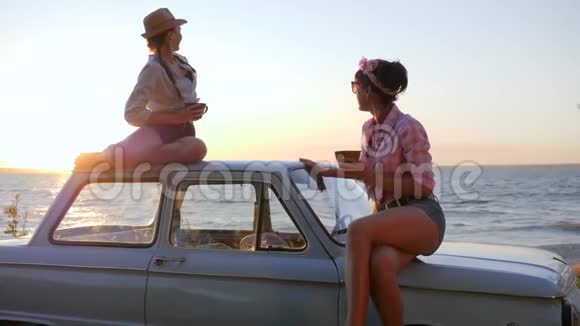 可爱的女朋友坐在屋顶和帽子汽车上喝咖啡朋友的茶派对在海上航行视频的预览图