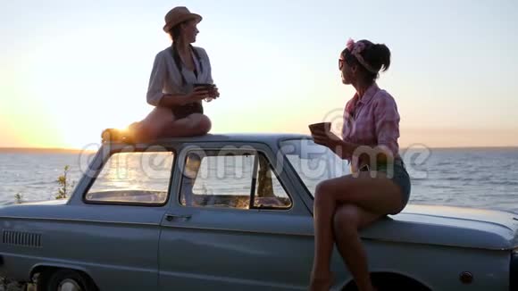 在日落时分朋友们在海边的机器上举行茶会可爱的女朋友在喝咖啡视频的预览图