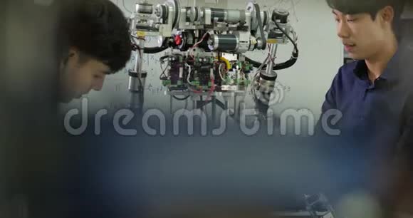 青年电子工程师团队合作在车间建造机器人视频的预览图