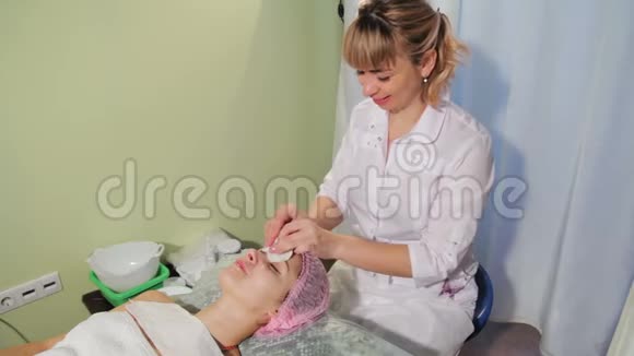 美容师用海绵清洁皮肤女人躺在沙发水疗沙龙上接受水疗治疗的妇女视频的预览图