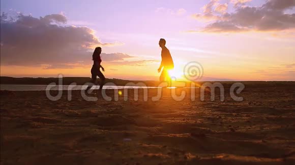 爱上一个男人在夕阳的背景下抱着一个女孩在蓝天的背景下人们的剪影视频的预览图