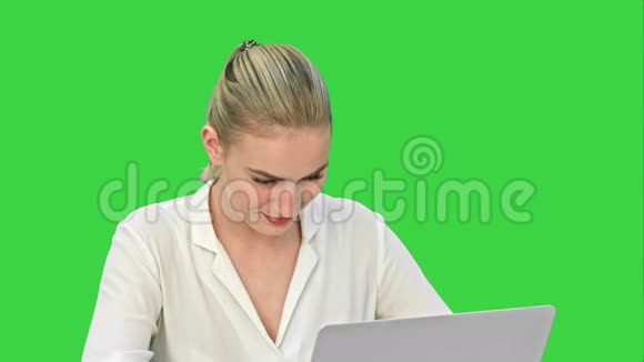 漂亮的年轻商务女性正在绿色屏幕上的笔记本电脑上工作Chroma键视频的预览图