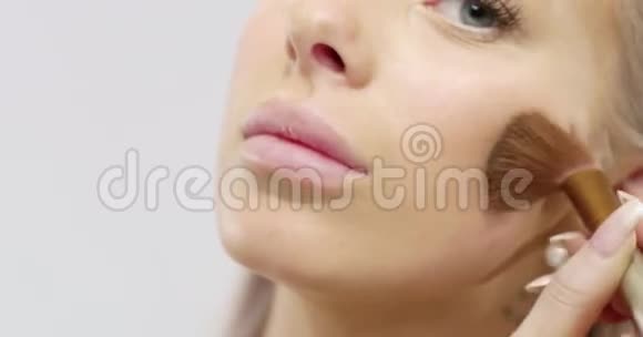 一位年轻美丽的女士用干化妆品粉底视频的预览图