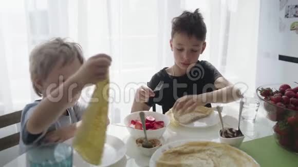 孩子们把草莓卷成薄饼孩子们吃煎饼视频的预览图