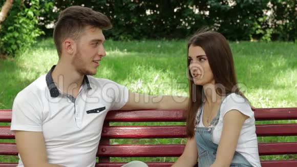 他在公园里的女孩的长椅上调情和娱乐视频的预览图