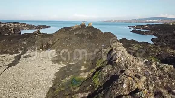 在英国安格列西威尔士的牛湾上空飞过岩石的无人机阴影的鸟瞰图视频的预览图