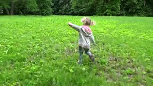 美丽的金发女孩在公园的草地上奔跑可爱的孩子在户外玩得开心视频的预览图